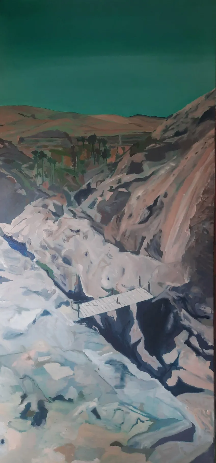 Een smal, verticaal landschap met een wandelpad tussen lichte rotsen onder een groenblauwe lucht.